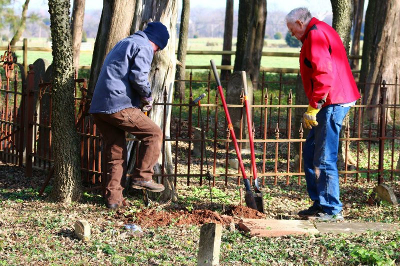 Robert Moser (left) and Bill Olson working to reset a headstone. Two men digging in the ground